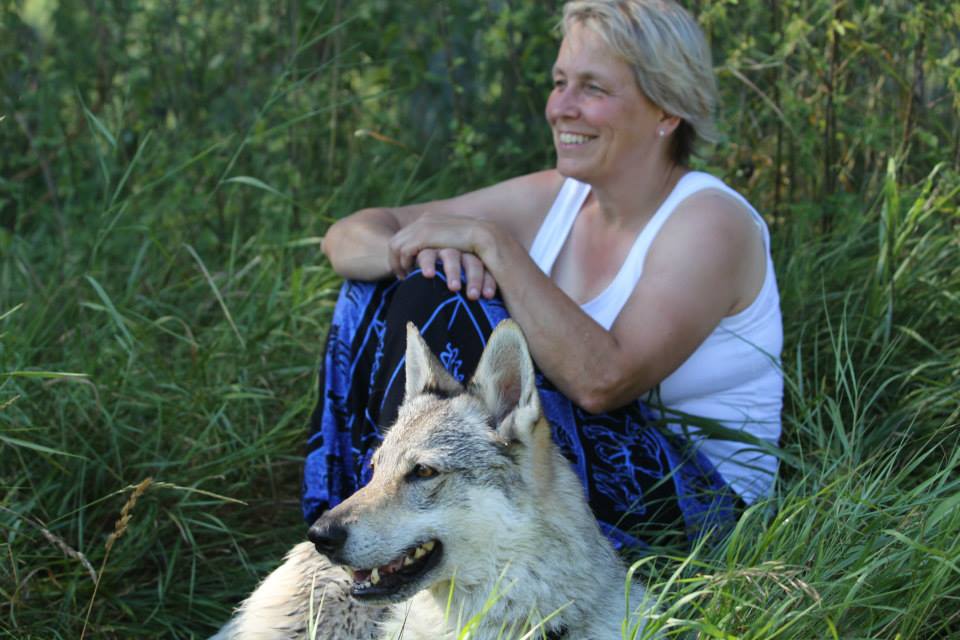 Porträt von Ina Ziebler-Eichhorn, sitzend im Gras neben ihrem Tschechoslowakischen Wolfhund
